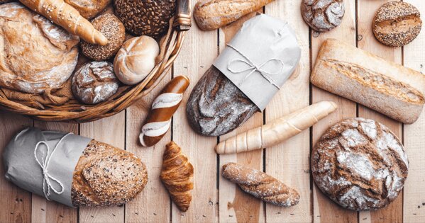 Verschiedene Backwaren wie Laugenstangen, Crossaint oder Brötchen auf einen Tisch verteilt